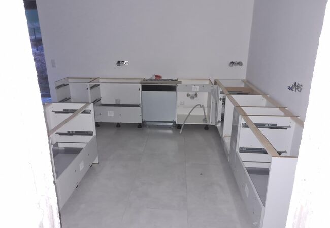 Aufbau einer neuen Küche - Teile der aufgebauten Unterschränke, weißer Korpus