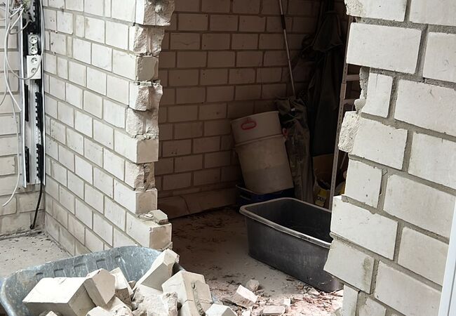 mauer mit druchbruch, steine in der schubkarre