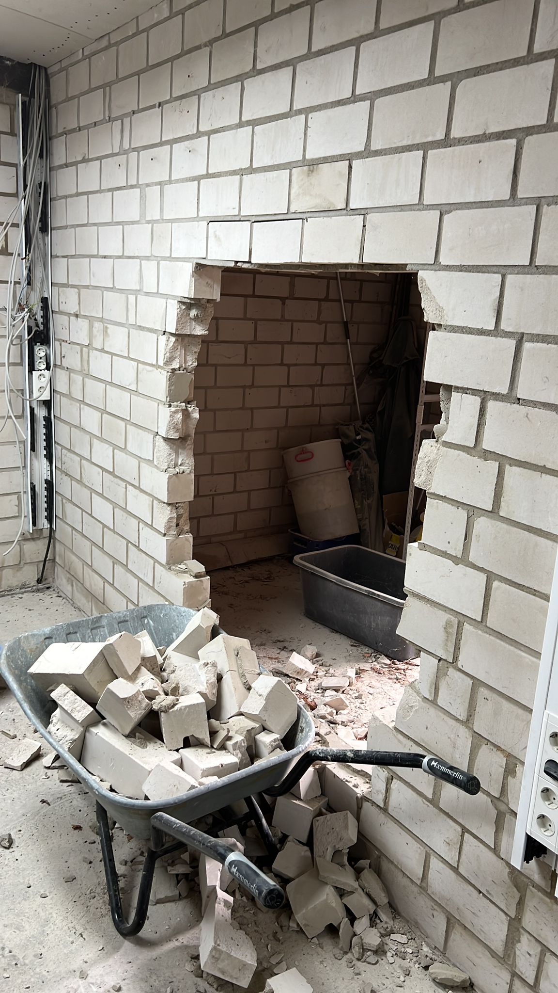 mauer mit druchbruch, steine in der schubkarre